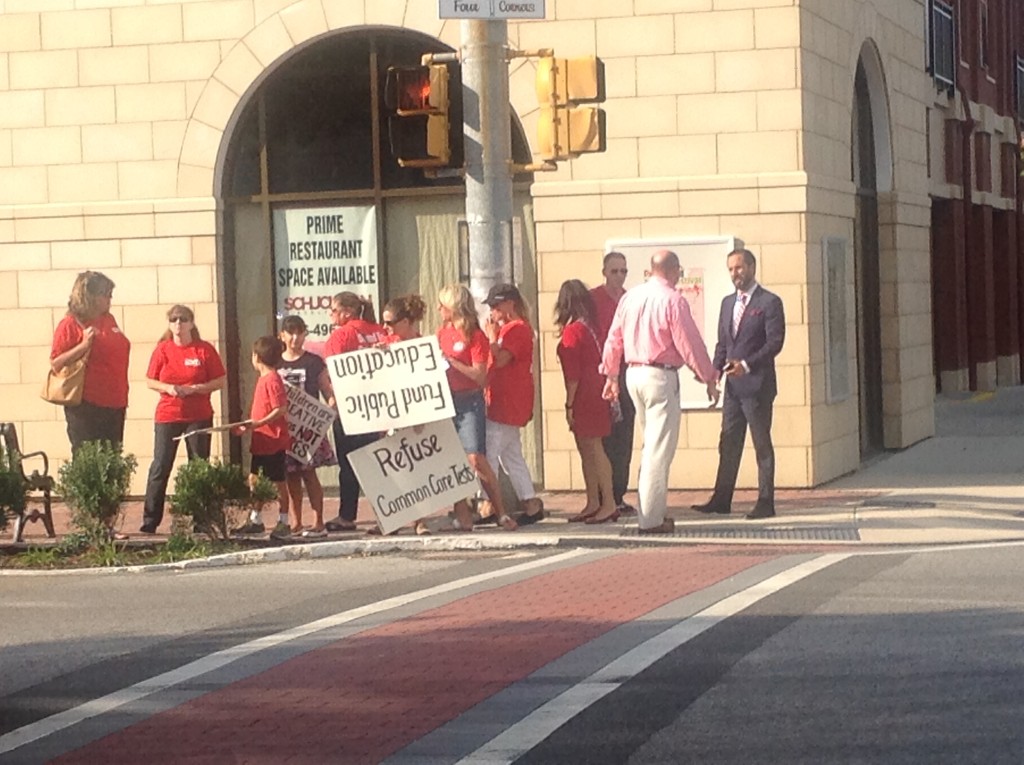 A Group of People in Red Tops Holding Slogans