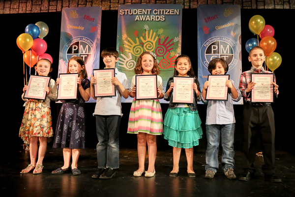 A Group of Children Holding Awards on Stage Twenty