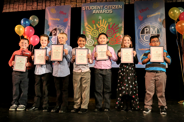 A Group of Children Holding Awards on Stage Twenty One