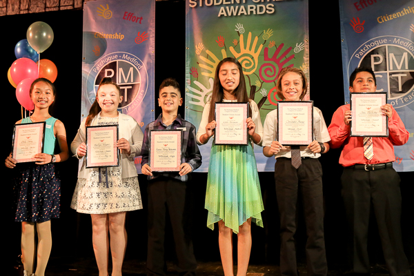 A Group of Children Holding Awards on Stage Twenty Three